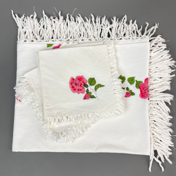 Tischdecke und Servietten mit handgemalten Blumen.