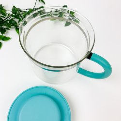 Teekanne aus Glas mit trkisfarbenem Deckel.